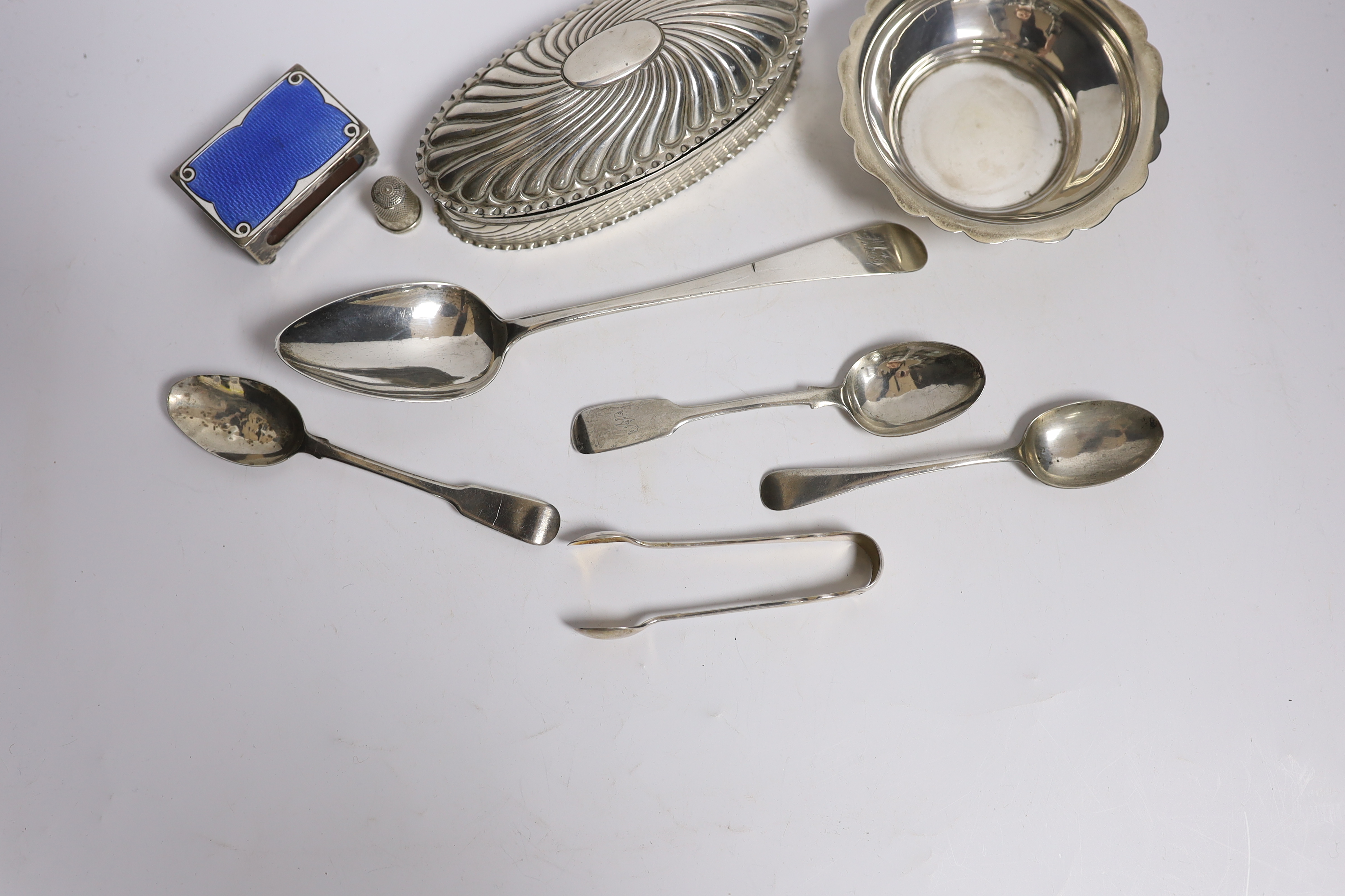 A late Victorian repousse silver oval trinket box by Horton & Allday, Birmingham, 1890, 15.2cm, together with five items of silver flatware, a silver bowl, silver and enamel matchbox sleeve and a sterling thimble.